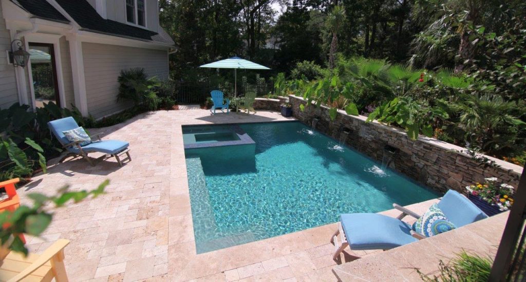 Pool with spa and a stone wall with waterfalls | Aqua Blue Pools