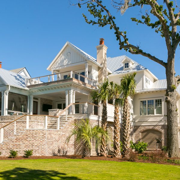 Backyard pool with large house and palm tree