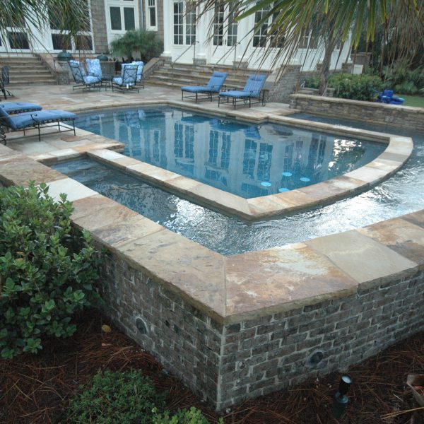 Backyard pool with waterfall surrounding the pool edge