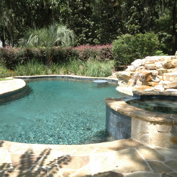 Outdoor pool with rock waterfall and circle hot tub