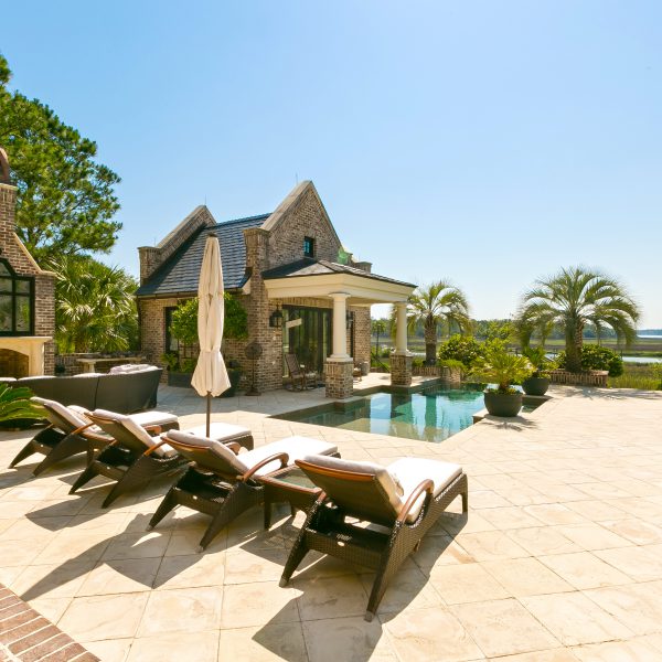 Backyard overview with tanning beds and an infinity pool