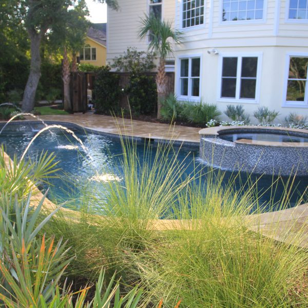 Backyard pool with water fountains and circle hot tub