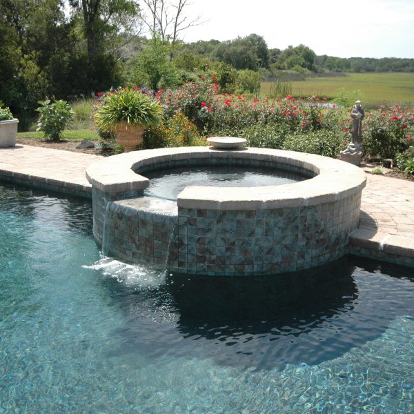 Hot tub with waterfall into bigger outdoor pool