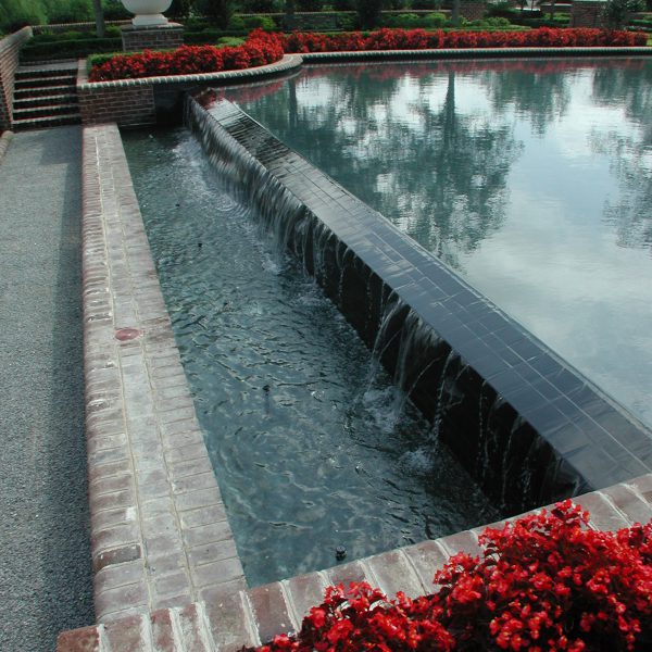 Outdoor water feature fountain with red flowers