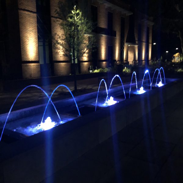 Outdoor water feature fountain at night with blue lights