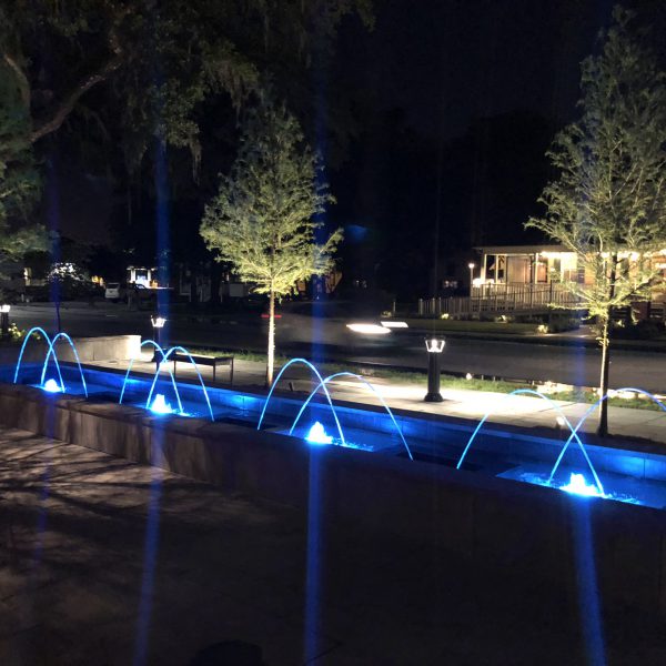 Outdoor water feature fountain at night with blue lights