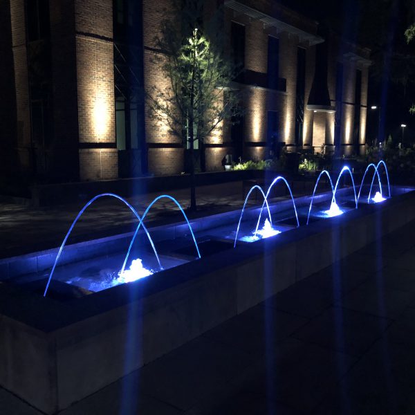 Outdoor water feature fountain at night with blue lights