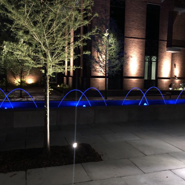 Outdoor water feature fountain at night with blue lights