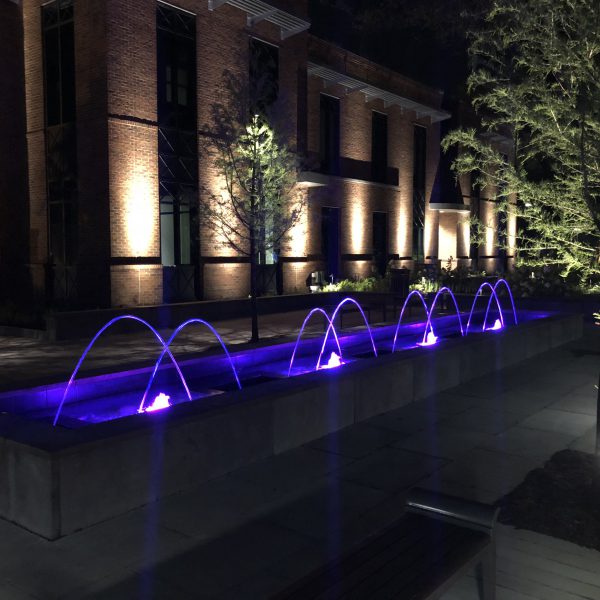 Outdoor water feature fountain at night with blue lights