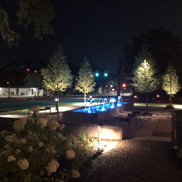 Outdoor water feature fountain at night with blue lights