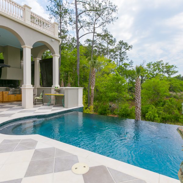 Custom Infinity Pool overlooking a backyard with a statue