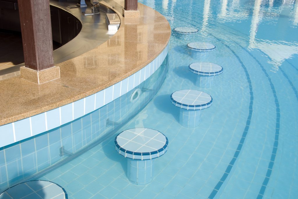 A swim up pool bar with stools within the swimming pool