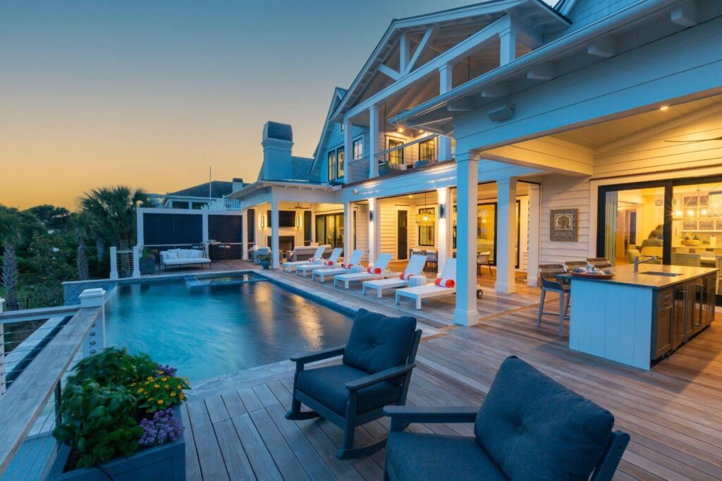 Backyard pool at sunset with lounge chairs and patio eating area
