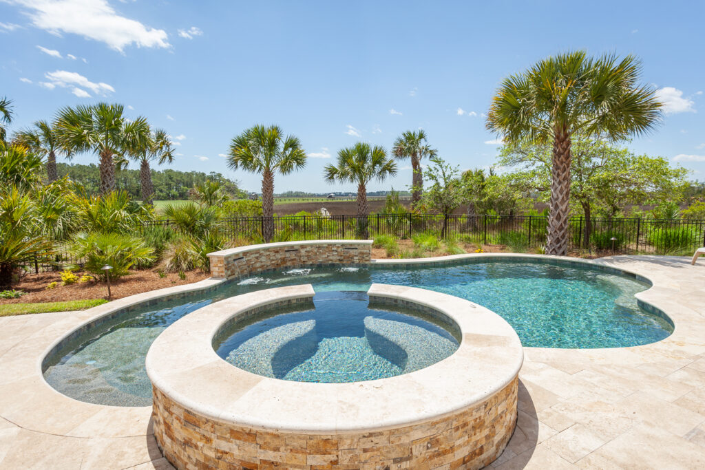Outdoor pool and hot tub with palm trees in the background