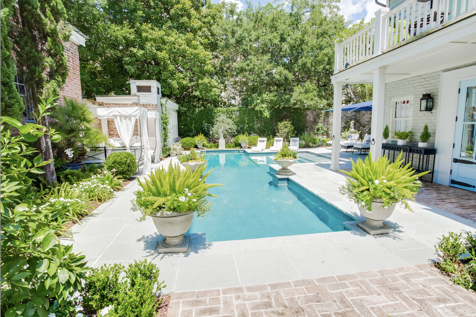 Backyard pool with lots of greenery and plants on the pool deck