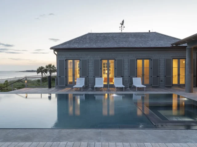 Infinity pool overlooking the beach at a luxurious coastal home.
