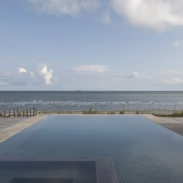 Stunning infinity pool with an ocean view and a wooden deck.