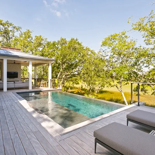 Modern lap pool with covered porch and marshfront views