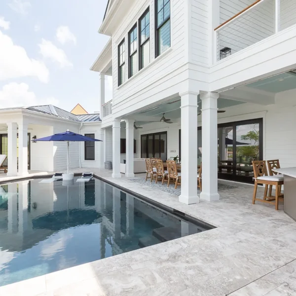 Covered patio with poolside kitchen and modern infinity pool design