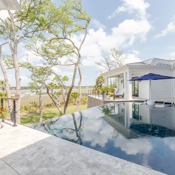 Infinity pool with ocean-inspired backdrop and coastal landscaping