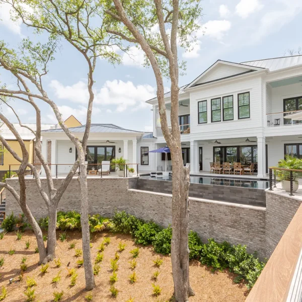 Rear exterior view of waterfront home with infinity edge pool