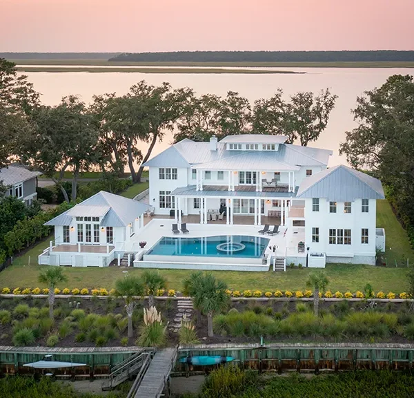 Aerial view of luxury waterfront estate with large infinity pool