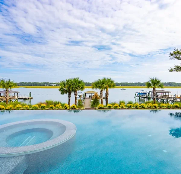 Infinity pool with built-in circular spa and waterway backdrop