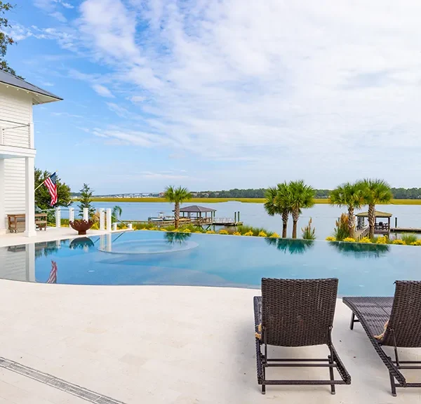 Backyard pool and spa facing river with dock access and palm trees