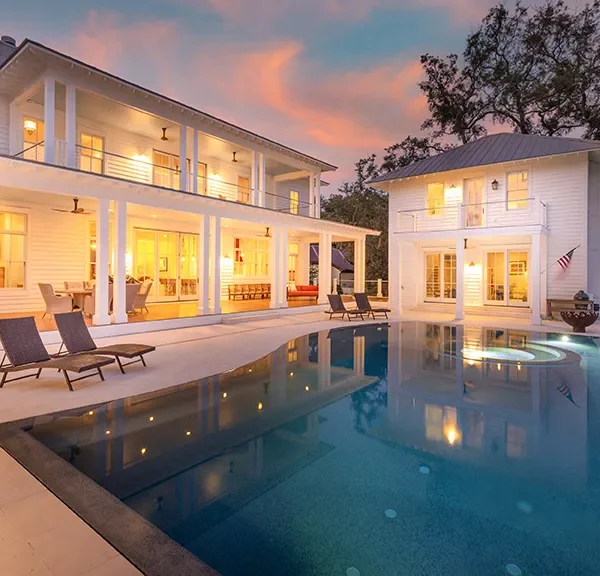 Modern southern estate with covered porch and reflective infinity pool