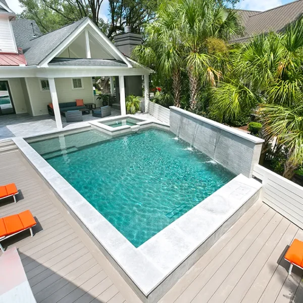 Elevated view of a modern backyard pool, spa, waterfalls, and outdoor living area.