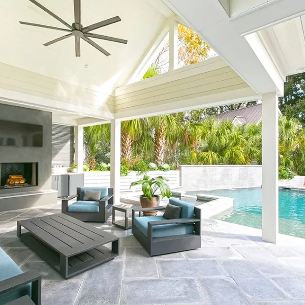 Covered patio with a fireplace, TV, outdoor kitchen, and a view of the pool and spa.