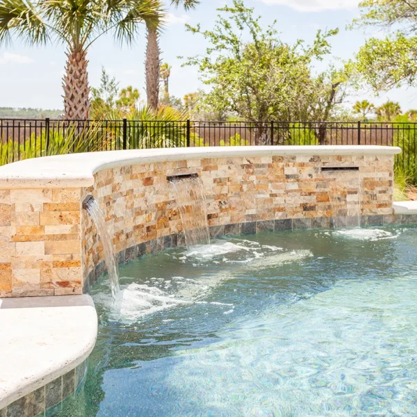 Close-up of pool waterfalls cascading over a stone feature.