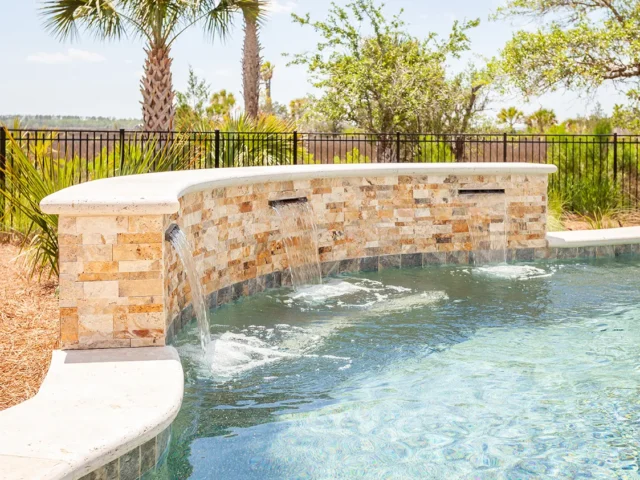 Close-up of pool waterfalls cascading over a stone feature.